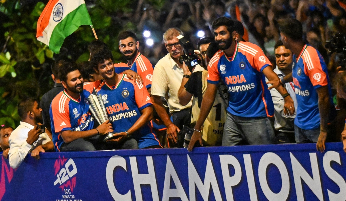 Indian cricketers with the T20 World Cup trophy gesture during an open bus roadshow upon their arrival in Mumba